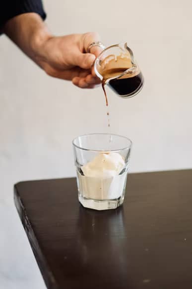  Pouring espresso over ice cream to make Affogato