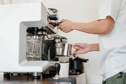 A barista is using Panarello-style steam wand