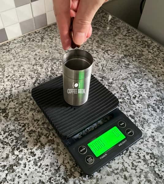 Weigh coffee beans by a digital scale.