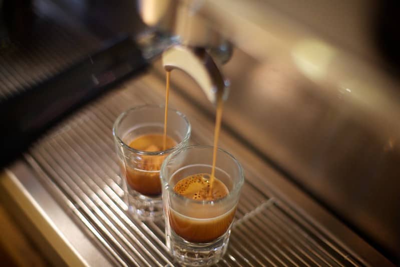 two shots of espresso being extracted from machine