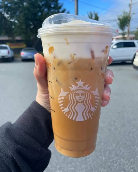 An iced blonde vanilla latte with vanilla sweet cream cold foam and caramel drizzle 