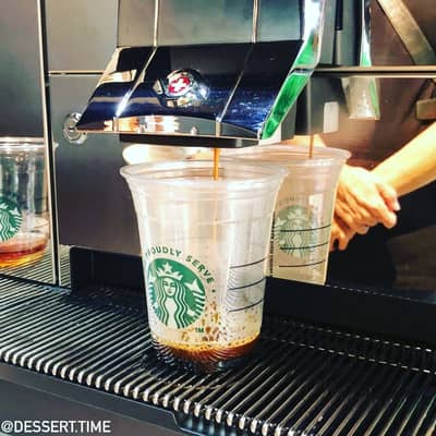 Barista making a Caffè Americano using a Starbucks espresso machine