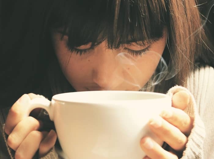 Closeup shot of woman drinking hot coffee from a cup