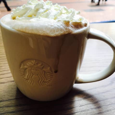 Hot chocolate topped with whipped cream in a branded Starbucks mug
