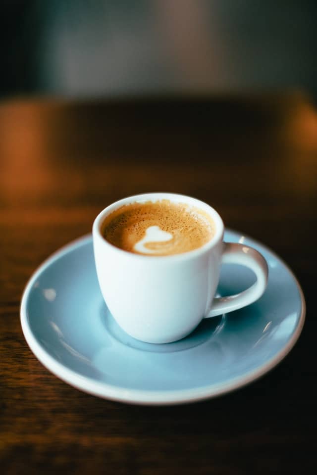 An espresso macchiato in a white demitasse cup