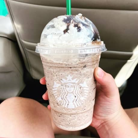Person holding a Double chocolate Chip Creme Frappuccino inside a car