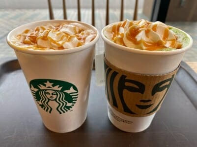 Duo of Caramel Macchiatos in Starbucks branded cups on a table