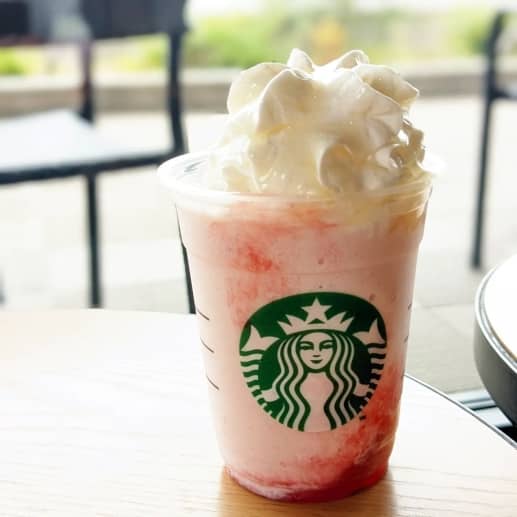  Starbucks Strawberry Frappuccino: Non-coffee based blended beverage with heavy cream on a table