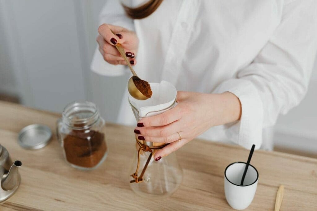 A woman scooping coffee powder
