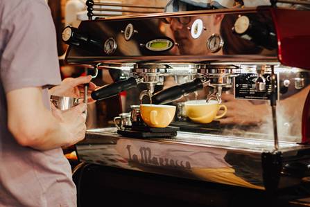 A professional barista using an espresso machine
