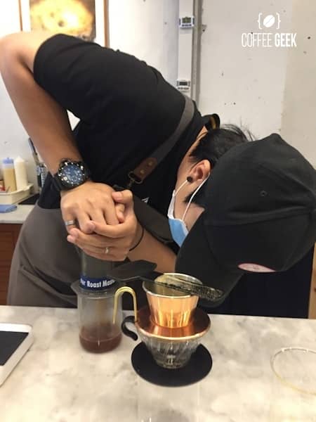 A person making coffee using an Aeropress