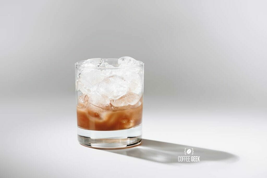 A glass of cold brewed coffee with ice cué on white tabletop 