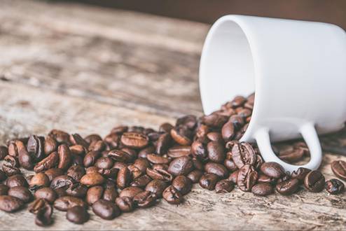 Roasted coffee beans and a white mug