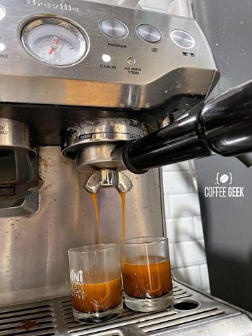 A coffee machine filling two  mugs