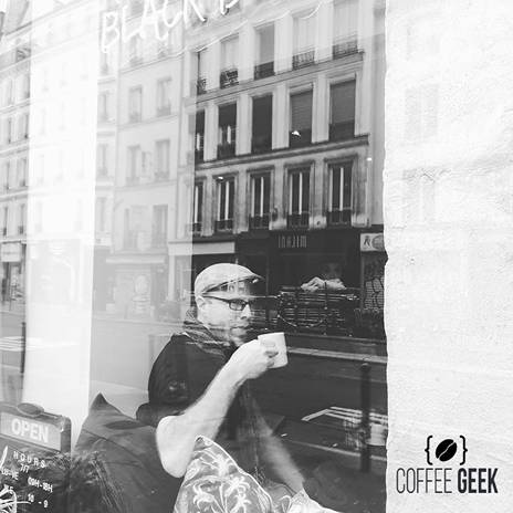 A man drinking coffee in a cafe in Paris. 