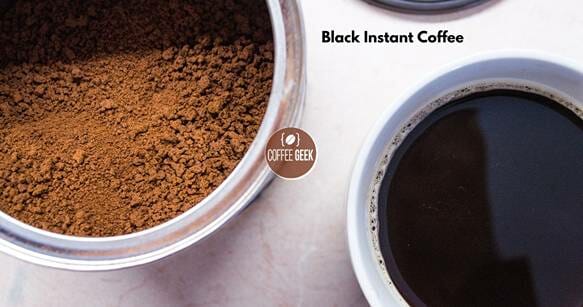 A cup of black instant coffee next to a bowl of coffee.