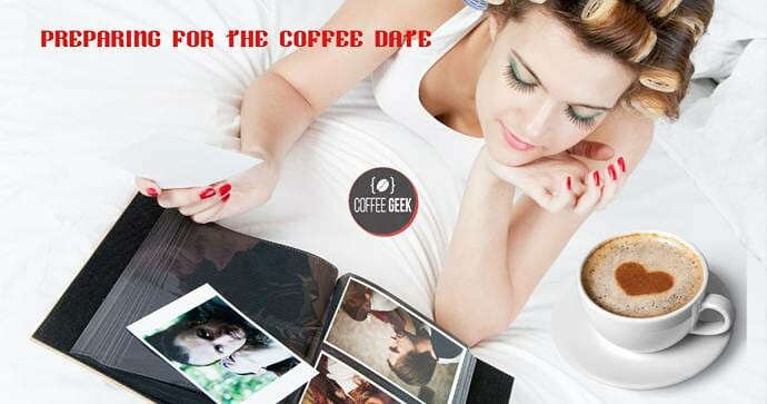 A woman is laying on a bed with a cup of coffee.