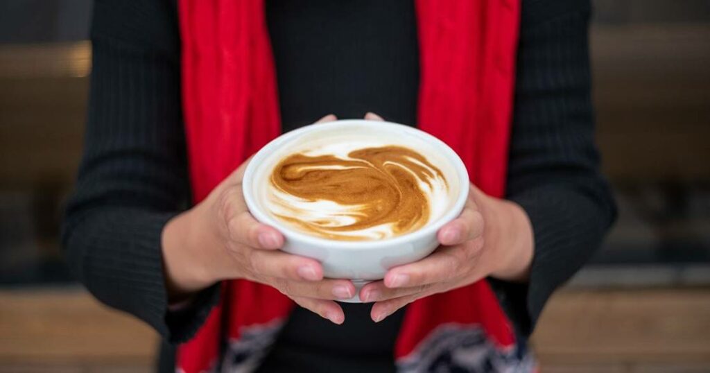 A woman holding a cup of coffee.
